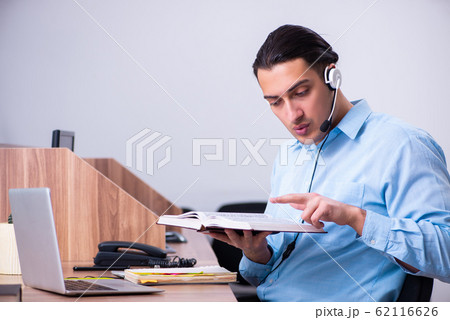 Call center operator working at his desk Call center operator working at his desk 62116626