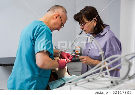 Young female patient takes a dental attendance in the dentist's office. 62117339