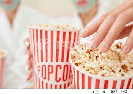 Selective focus of popcorn boxes in female arms. Selective focus of popcorn boxes in female arms. 62119385