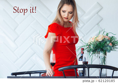 Young elegant beautiful girl picks from the table in the kitchen a glass of wine Young elegant beautiful girl picks from the table in the kitchen a glass of wine 62120185