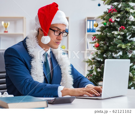 Businessman celebrating christmas holiday in the office 62121102