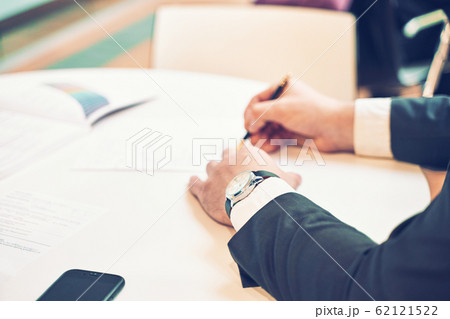 Silhouette of cropped shot of a young man working from home using smart phone and notebook computer, man's hands using smart phone in interior, man at his workplace using technology, flare light Silhouette of cropped shot of a young man working from home using smart phone and notebook computer, man's hands using smart phone in interior, man at his workplace using technology, flare light 62121522