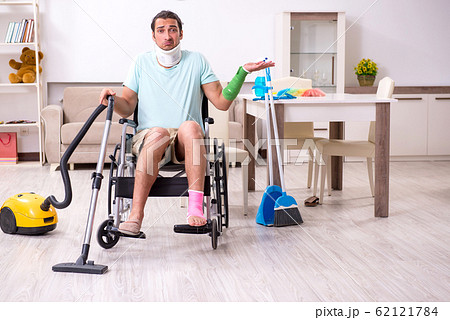 Young man in wheel-chair cleaning the house 62121784