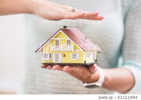 Hands of young woman holding model house 62121894