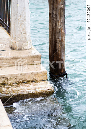 Stone steps leading into the canals of Venice. Water from the canals of Venice splash against the stone ground and steps. 62122002