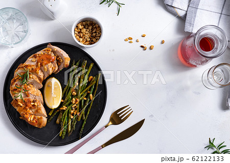Grilled chicken breast with grilled asparagus and lemon slice on stone. Paleo diet. Concept for a tasty and healthy meal. 62122133