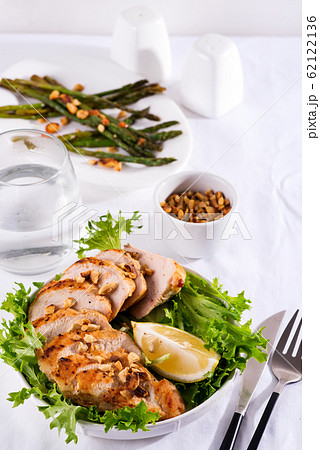 Grilled chicken breast with grilled asparagus and lemon slice. Paleo diet. Healthy nutrition. Concept for a tasty and healthy meal. Grilled chicken breast with grilled asparagus and lemon slice. Paleo diet. Healthy nutrition. Concept for a tasty and healthy meal. 62122136