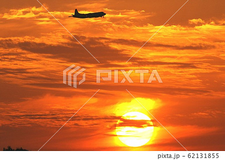 空一面を茜色に染める夕日の空を飛行する海上自衛隊のP-3Cオライオン哨戒機 62131855