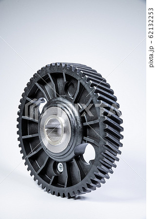 Black polymer gear camshaft with metal base. New spare part for an internal combustion engine on a gray background Black polymer gear camshaft with metal base. New spare part for an internal combustion engine on a gray background 62132253