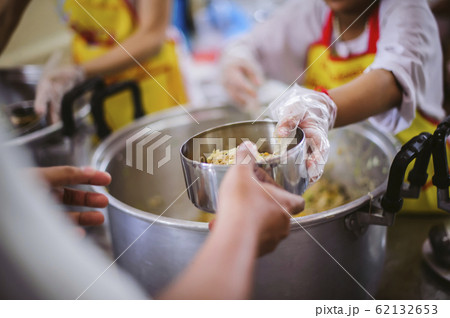 Volunteers provide free food to the Volunteers provide free food to the 62132653