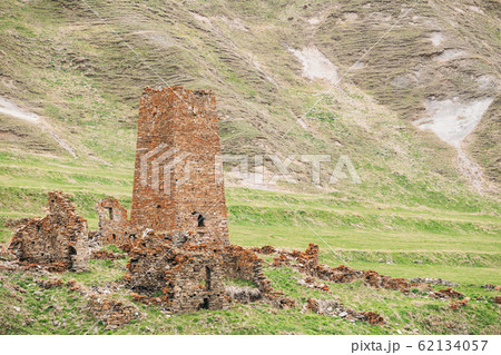 Ancient Old Stone Watchtower On Mountain Background In Chetoyta Or Zakagori Village, Kazbegi District, Mtskheta-Mtianeti Region, Georgia. Spring, Summer Season. Truso Gorge. Ancient Old Stone Watchtower On Mountain Background In Chetoyta Or Zakagori Village, Kazbegi District, Mtskheta-Mtianeti Region, Georgia. Spring, Summer Season. Truso Gorge. 62134057