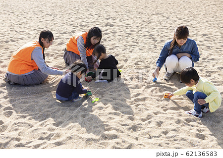 子供達と遊ぶ高校生の写真素材