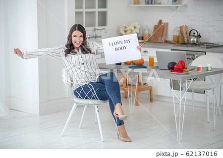 Dark-haired woman in a striped blouse looking happy 62137016