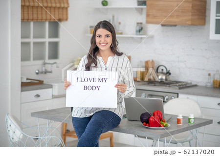 Dark-haired woman in a striped blouse smiling nicely Dark-haired woman in a striped blouse smiling nicely 62137020