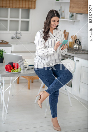 Long-haired woman in a striped blouse searching for information online Long-haired woman in a striped blouse searching for information online 62137077