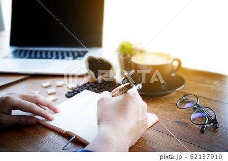 Male manager putting his ideas and writing business plan at workplace,man holding pen and making note in notebook , on the table in office,vintage color,morning light ,selective focus. Male manager putting his ideas and writing business plan at workplace,man holding pen and making note in notebook , on the table in office,vintage color,morning light ,selective focus. 62137910