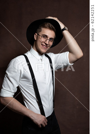 Man in round glasses, suspenders, a white shirt Man in round glasses, suspenders, a white shirt 62142251
