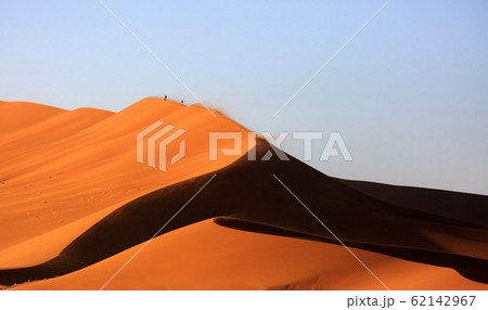 Beautiful landscape with red huge sand dunes at sunset in desert. Sossusvlei, Namib Naukluft National Park, Namibia. Stunning natural geometry without people 62142967