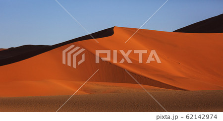 Beautiful landscape with red huge sand dunes at sunset in desert. Sossusvlei, Namib Naukluft National Park, Namibia. Stunning natural geometry without people Beautiful landscape with red huge sand dunes at sunset in desert. Sossusvlei, Namib Naukluft National Park, Namibia. Stunning natural geometry without people 62142974