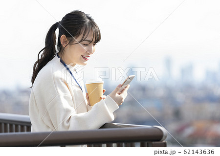 スマートフォンを操作する女性　ビジネスウーマンのコーヒーブレイク　イメージ 62143636