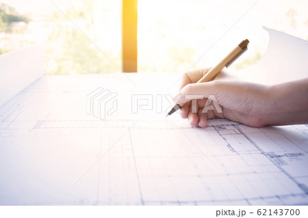Construction , designer and renovate concept. : Architect working on blueprint, architects workplace. Architectural drawning pencil working with new startup project, side view with light effect. 62143700