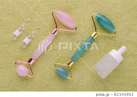 jade and rose quartz facial roller with face serum in ampoules and bottle, above jade and rose quartz facial roller with face serum in ampoules and bottle, above 62143952