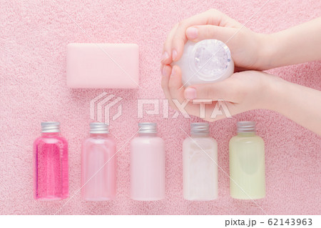 hands with a bottle and natural cosmetic, shampoo, lotion, shower gel and other products, above 62143963