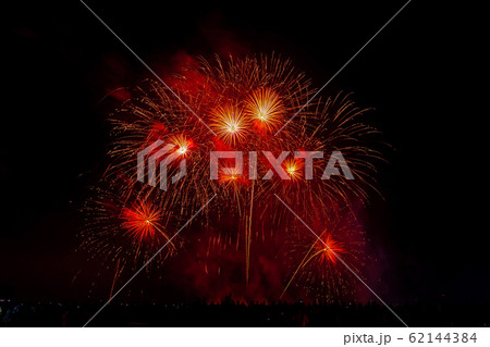 Crowd looks holiday fireworks in dark evening sky. Crowd looks holiday fireworks in dark evening sky. 62144384
