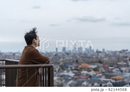 屋上で空を見上げる中高年男性の横顔の写真素材