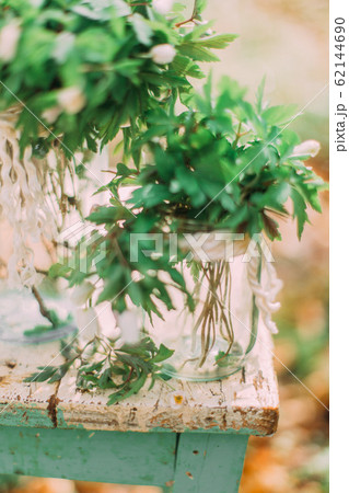 Bouquet of white spring flowers in Glass Jar On wooden chair in the forest outdoors Bouquet of white spring flowers in Glass Jar On wooden chair in the forest outdoors 62144690