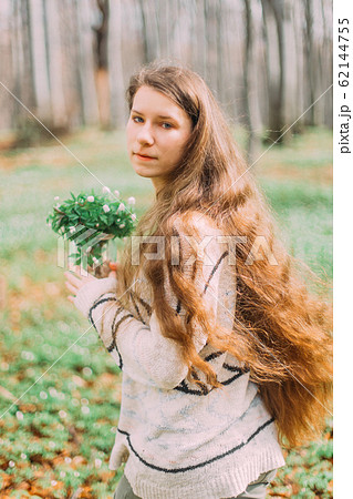 beautiful young girl woman walking through the green forest in spring, holding glass ar with white spring flowers beautiful young girl woman walking through the green forest in spring, holding glass ar with white spring flowers 62144755