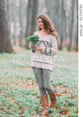 beautiful young girl woman walking through the green forest in spring, holding glass ar with white spring flowers beautiful young girl woman walking through the green forest in spring, holding glass ar with white spring flowers 62144765