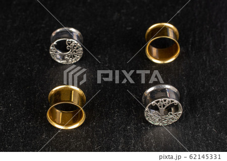 Stylish ear plug on grey stone 62145331