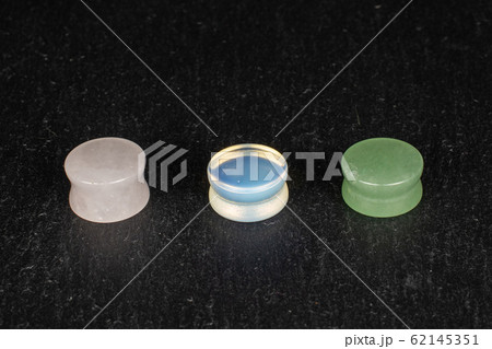 Stylish ear plug on grey stone 62145351