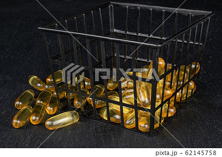 Golden fish oil on grey stone 62145758