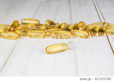 Golden fish oil on grey wood 62145780