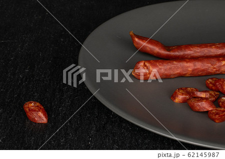 Smoked spicy sausage on grey stone Smoked spicy sausage on grey stone 62145987