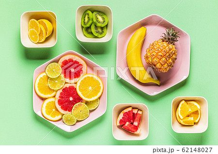 Tropical fruits whole and slices on plates 62148027