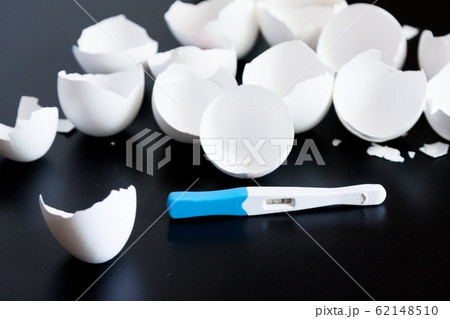 Infertility. Negative pregnancy test and eggshell on black background 62148510
