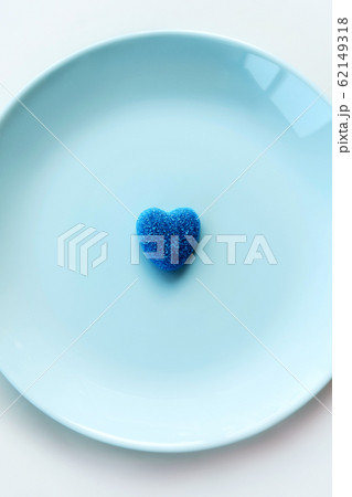 Blue lonely marmalade sugar heart on a light blue pastel plate 62149318