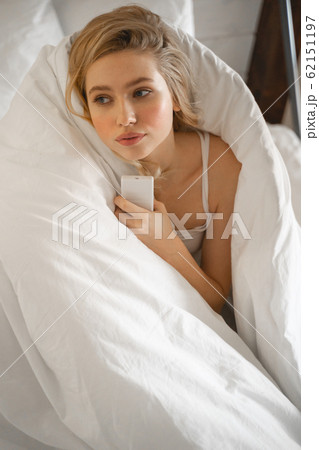 Cheerful blonde woman being deep in thoughts 62151197