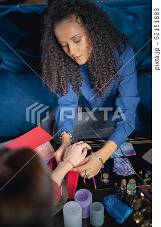 Female fortune-teller looking at her clients hand 62151883