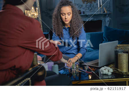 Fortune-teller turning tarot cards for her client 62151917