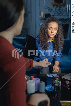 Soothsayer holding divination cards in front of her client 62151924