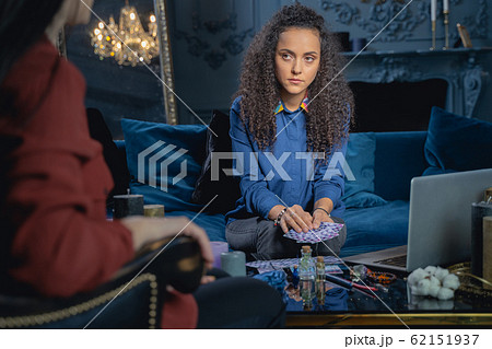 Serious female fortune-teller preparing for card reading Serious female fortune-teller preparing for card reading 62151937