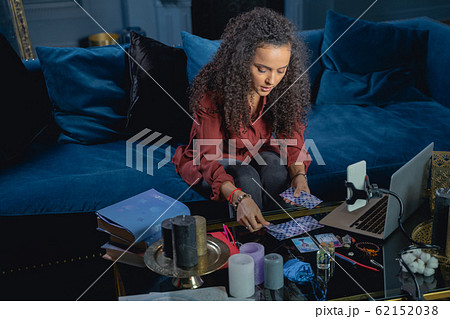 Young female laying out the tarot cards Young female laying out the tarot cards 62152038