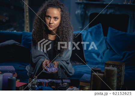 Young modern female fortune-teller holding tarot cards Young modern female fortune-teller holding tarot cards 62152625