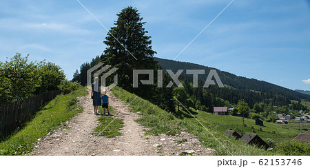 Mother and child walking on country road. Mother and child walking on country road. 62153746