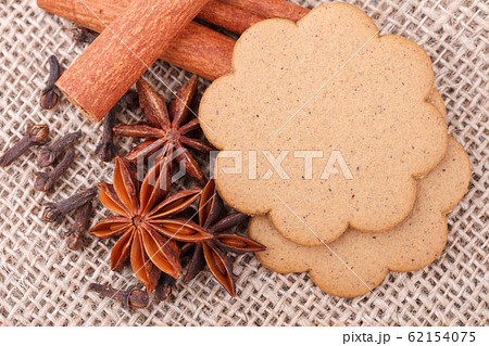 Gingerbread cookies, cinnamon, anise stars and and cloves on burlap background. Gingerbread cookies, cinnamon, anise stars and and cloves on burlap background. 62154075
