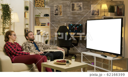 Couple relaxing on sofa watching on tv with green screen 62166399